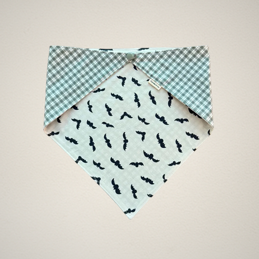 pet bandana with white fabric that has bats and green and white plaid fabric.