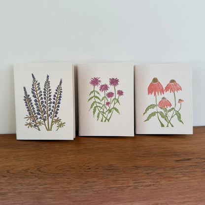 Three notebooks with floral designs on a wooden surface