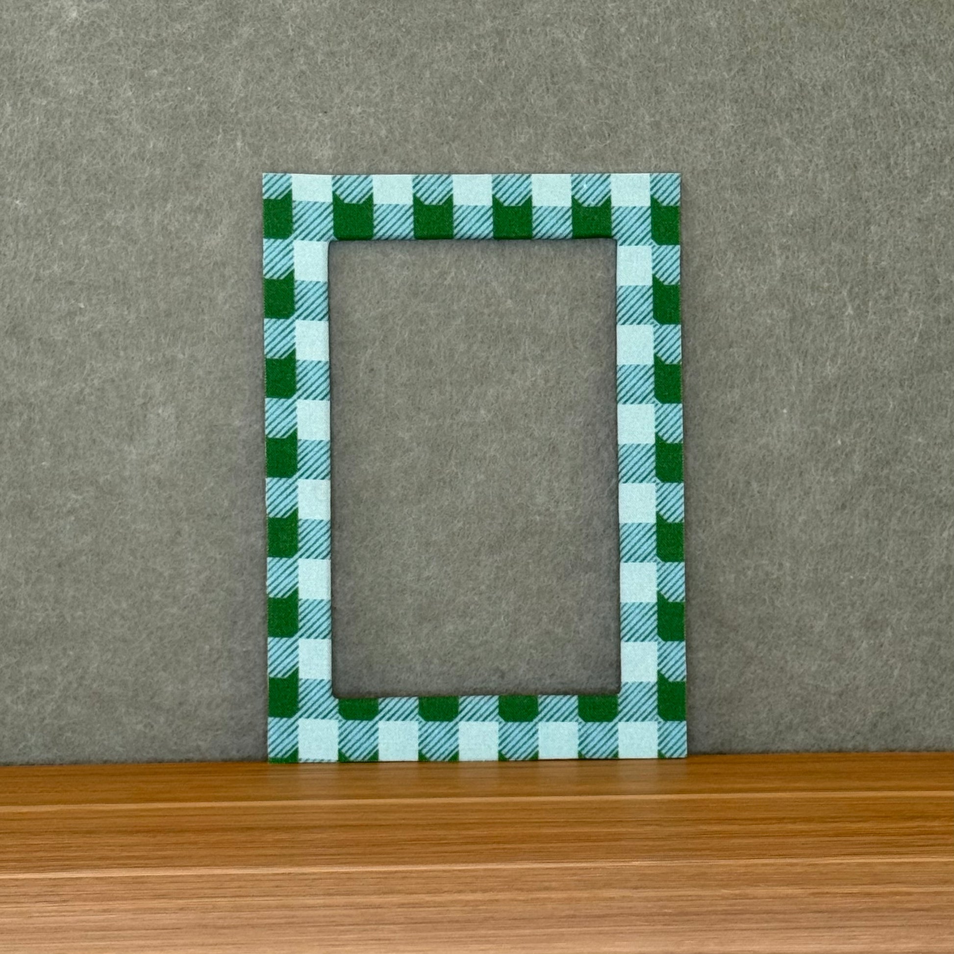  Blue and green plaid photo mat on a wooden surface with a gray background