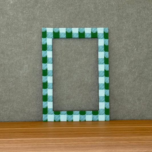  Blue and green plaid photo mat on a wooden surface with a gray background