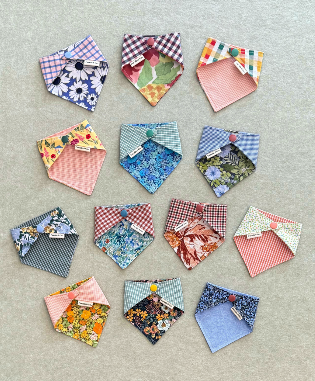 Collection of colorful fabric pet bandanas arranged on a textured surface