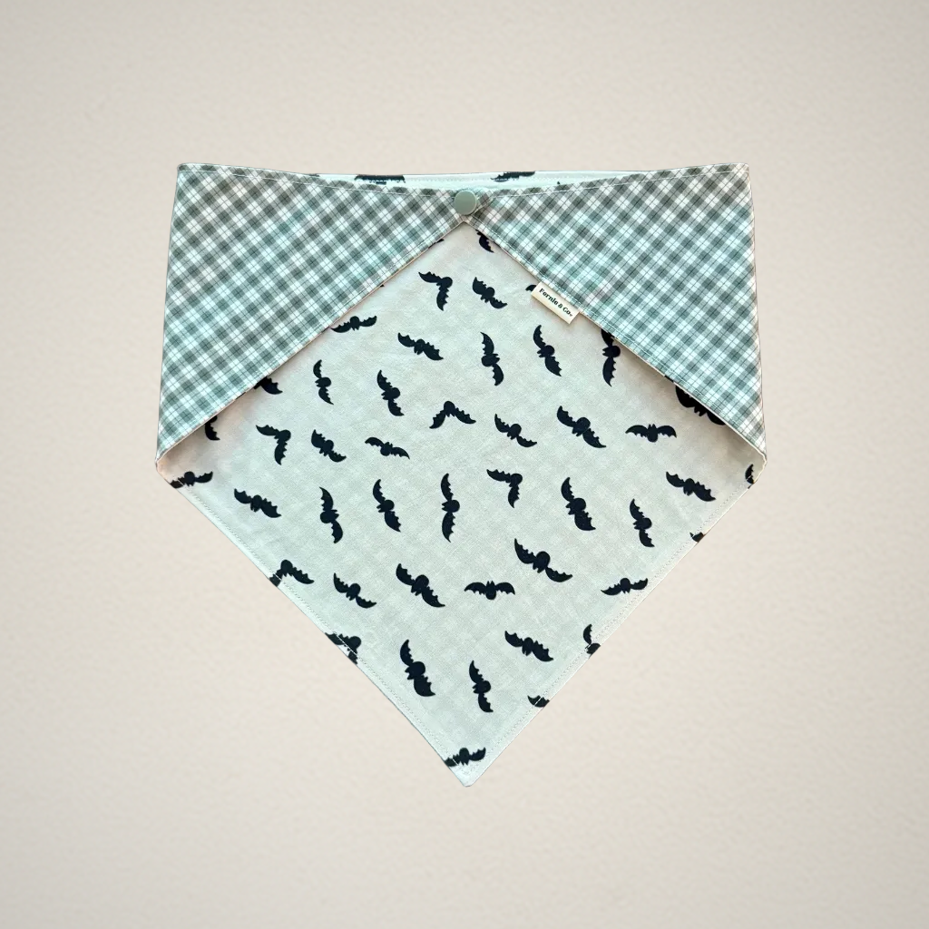 pet bandana with white fabric that has bats and green and white plaid fabric.