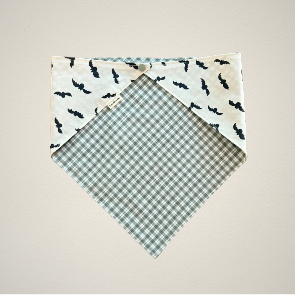 pet bandana with white fabric that has bats and green and white plaid fabric.