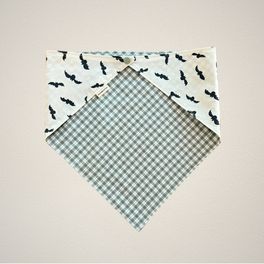 pet bandana with white fabric that has bats and green and white plaid fabric.